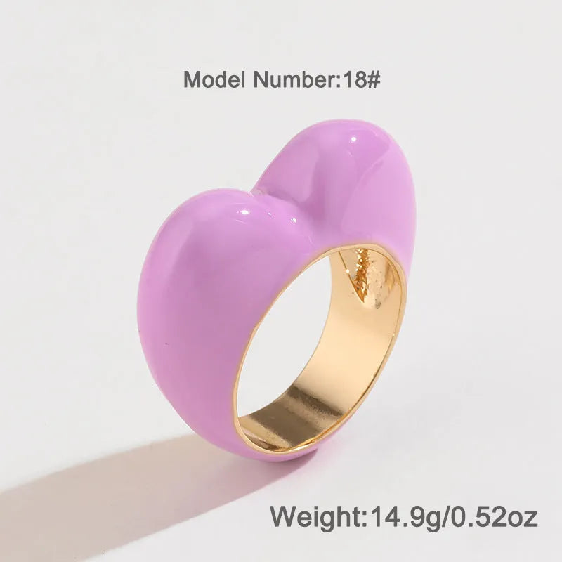 Close-up of a heart-shaped ring with a raised red enamel heart on a metallic band.