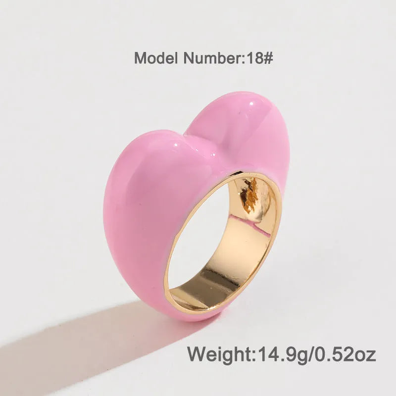 Close-up of a heart-shaped ring with a raised red enamel heart on a metallic band.