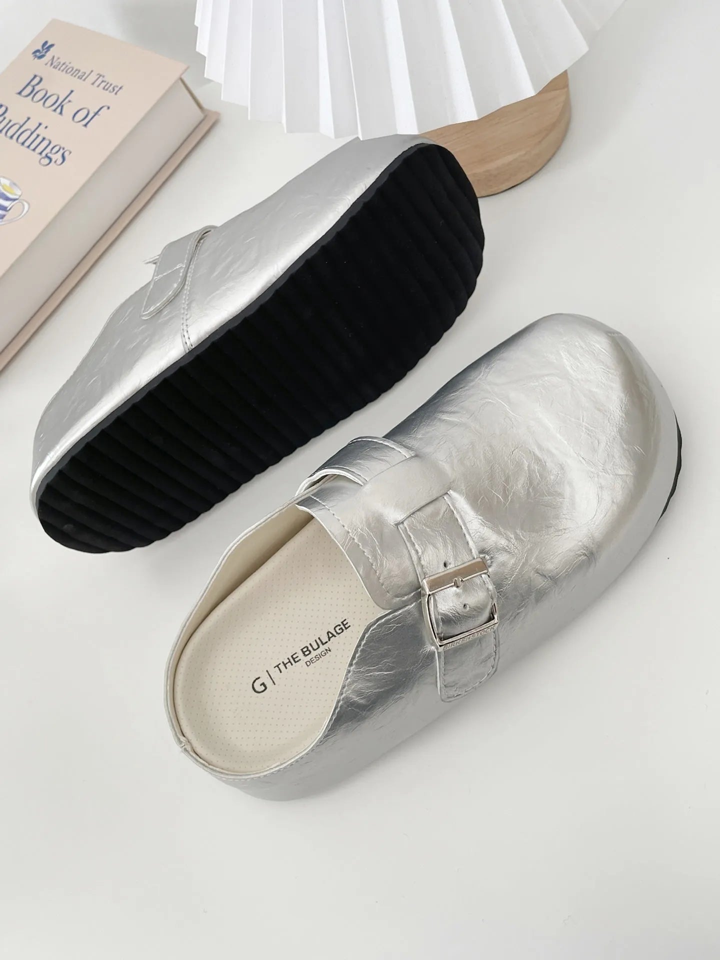 Flat buckle casual sneakers in yellow, black, silver, and creamy-white on a white background.