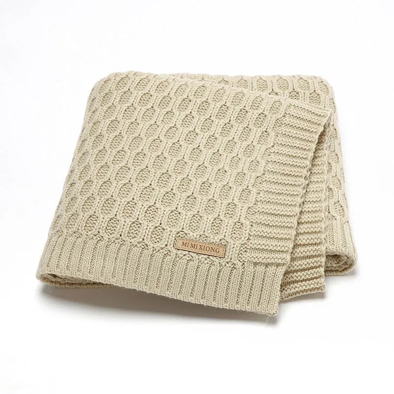 Solid colour infant hug blanket with three-dimensional line texture, shown in a choice of colours.