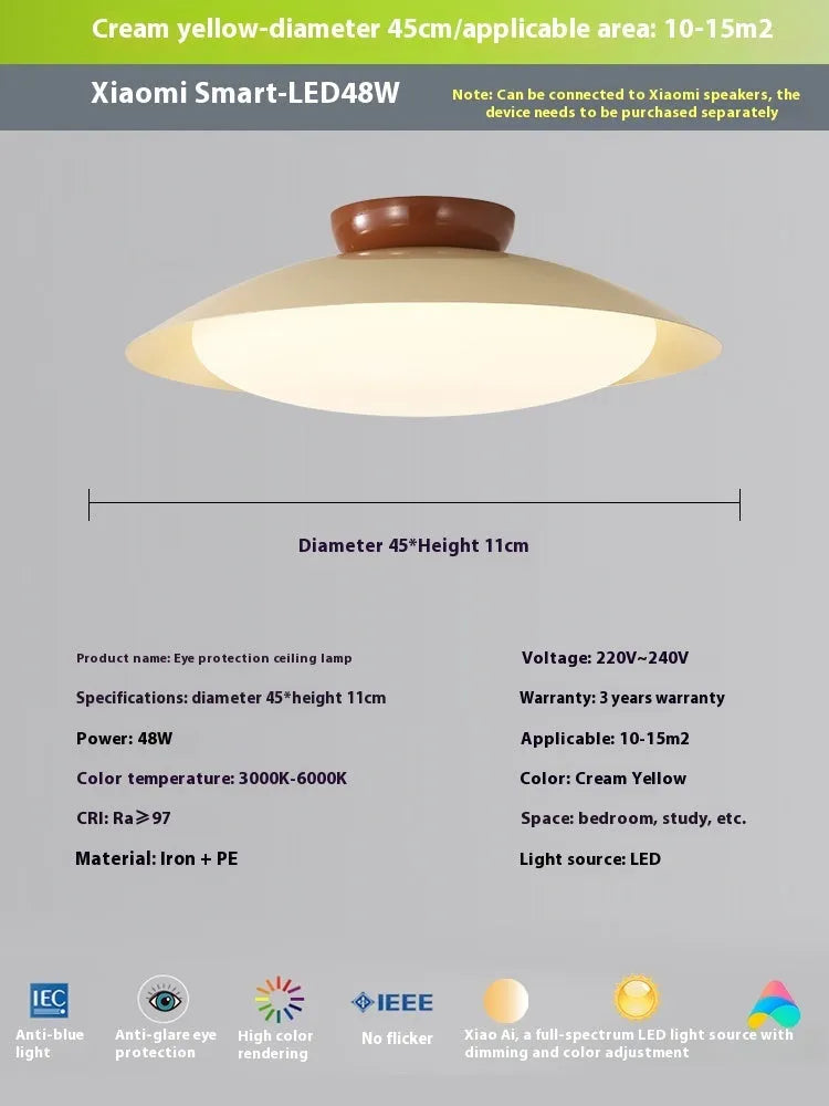 Modern flying saucer shaped ceiling lamp with an iron shade, shown in a cream yellow finish.