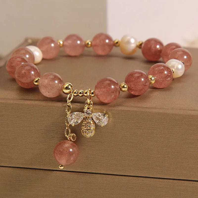 Strawberry quartz and freshwater pearl bracelet with zircon accents on woman's wrist