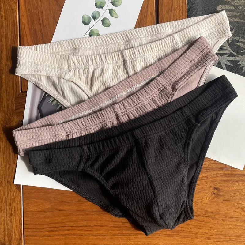 Men's solid colour cotton briefs with mid waist and triangle style in apricot black and skin colour.