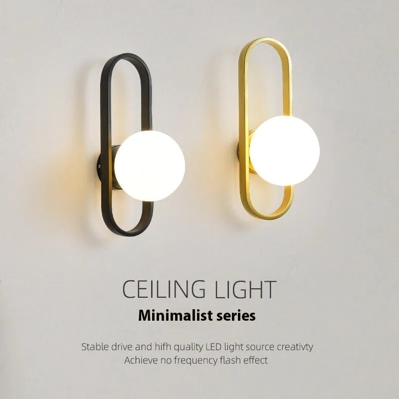 Modern minimalist wall lamp with glass shade and iron body in black or gold finish.