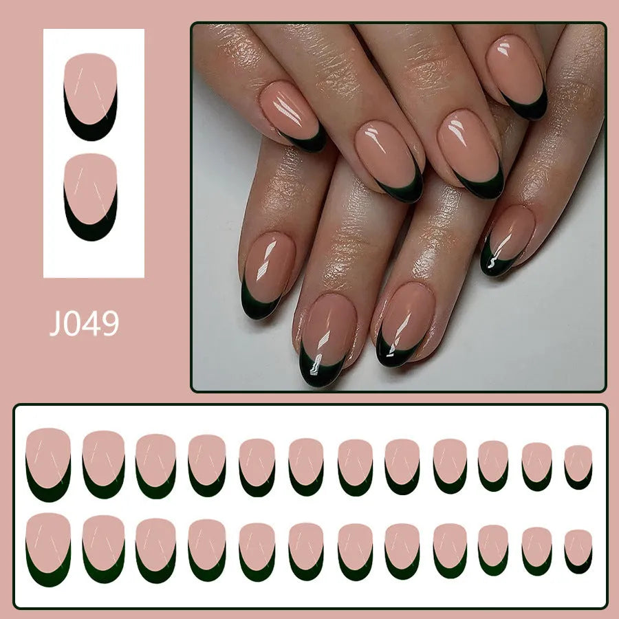Short almond shaped false nails with black French tips, set of 24 pieces laid out.