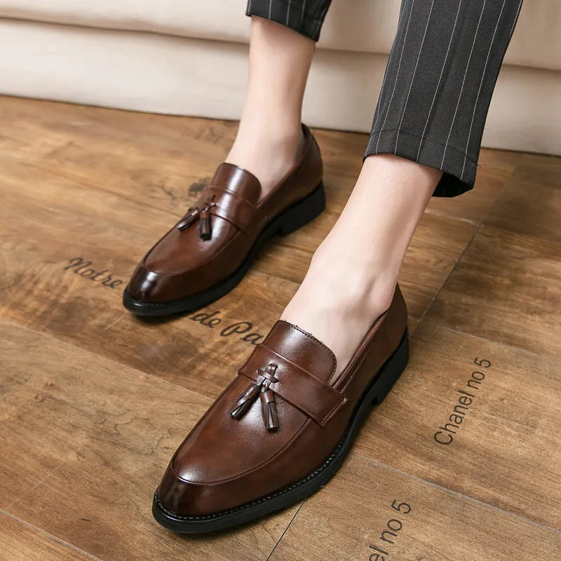Men's black slip-on business casual shoes with a tassel detail on the artificial PU upper