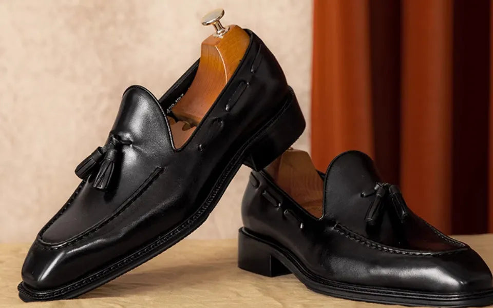 Men's brown leather loafers with fringed detail and slip-on design on rubber sole