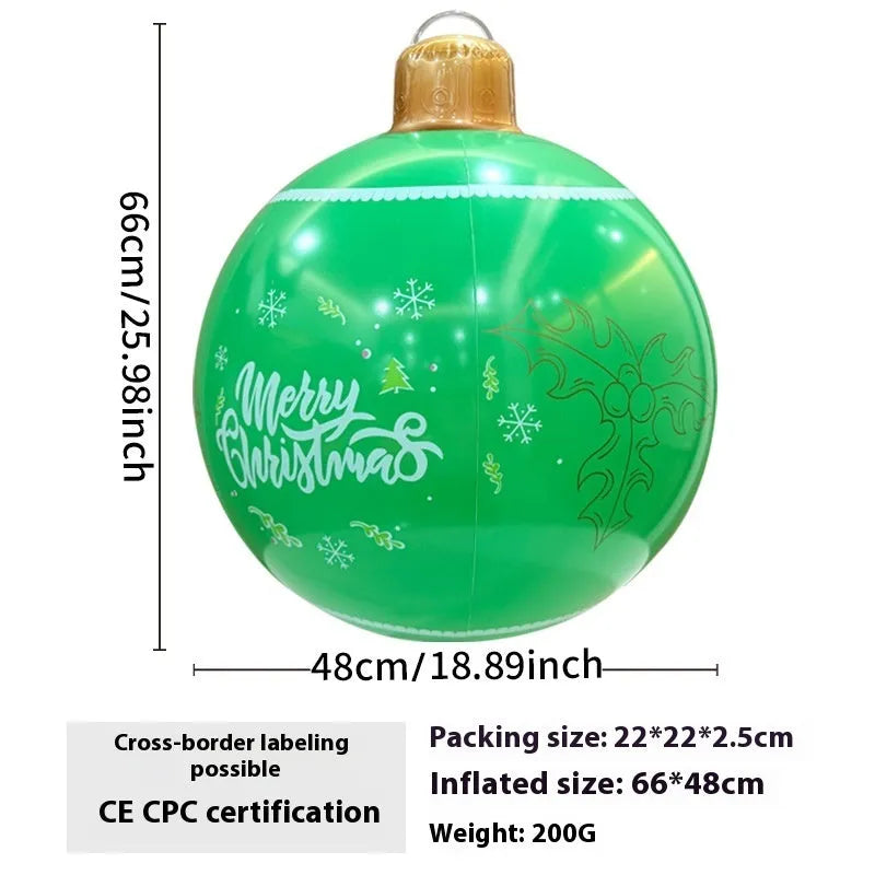 Large red and white inflatable Christmas ball with snowflake design in garden setting