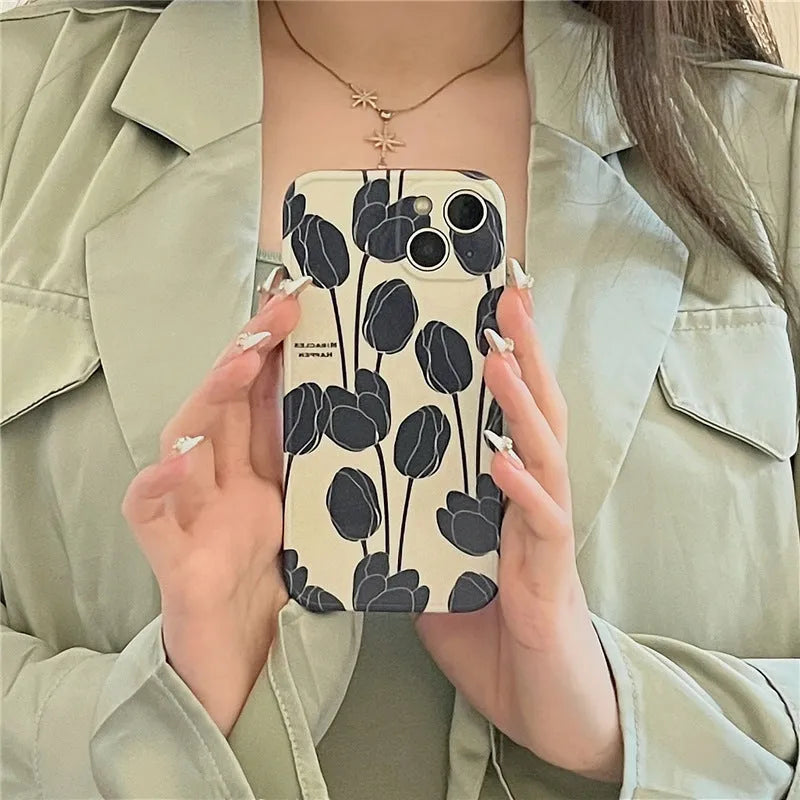 Black silicone iPhone case with a detailed tulip flower print on the back.