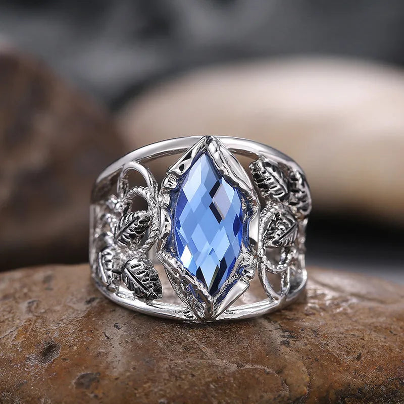Close-up of a women's horse eye shaped blue crystal ring on a finger.