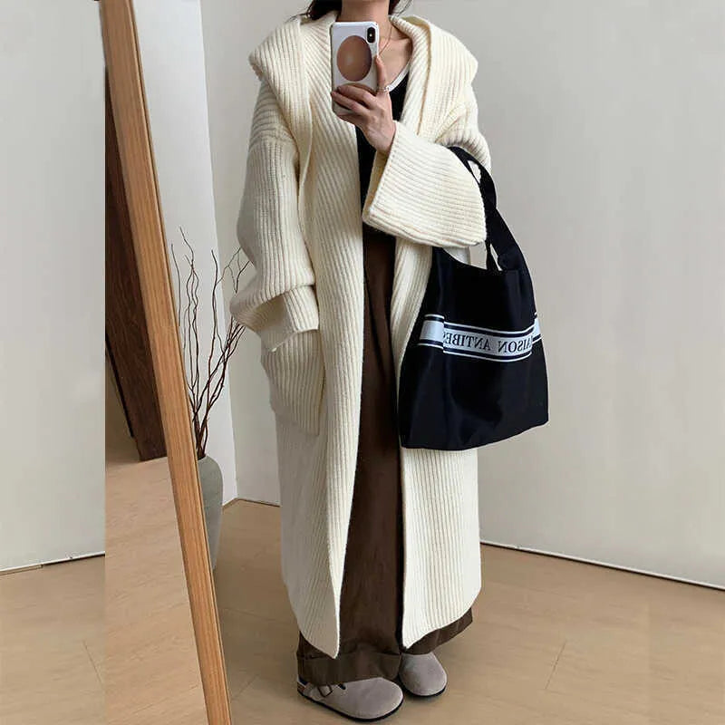 Loose hooded acrylic cardigan coat for women in beige, showing long length and raglan sleeves.