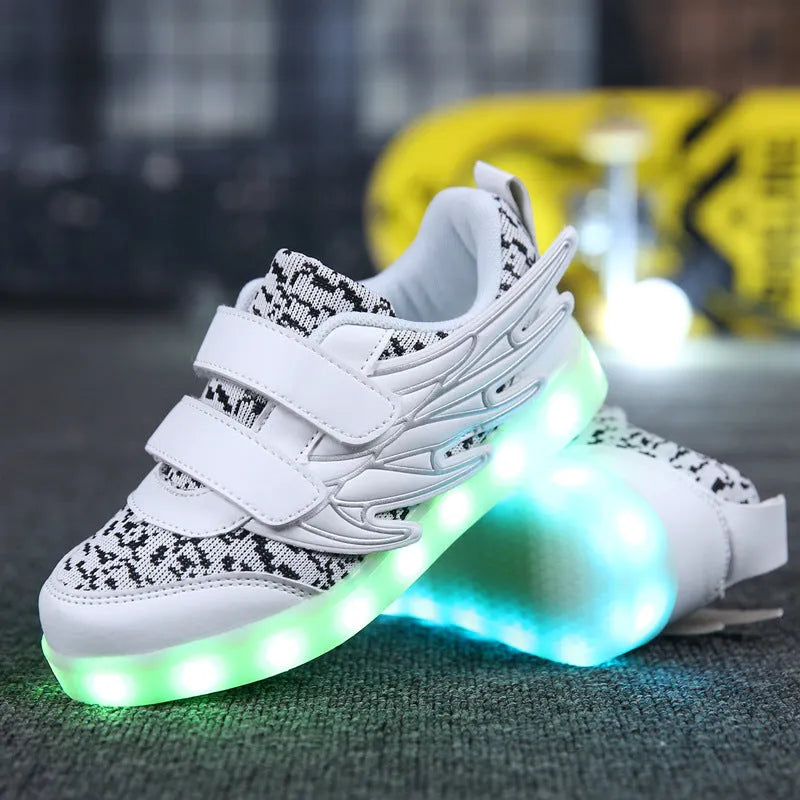 Children's plum red sneakers with multicolour LED lights glowing on the soles.