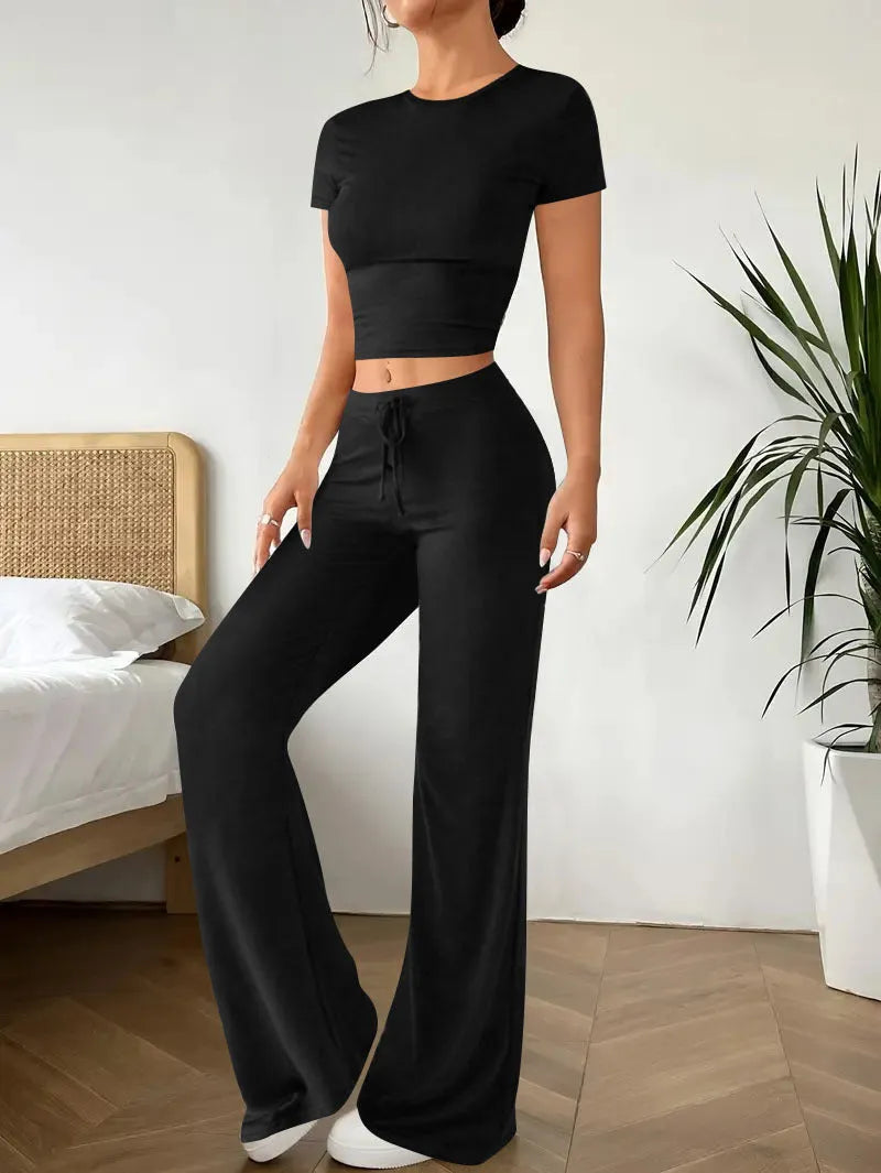 Black women's co-ord set with high waist trousers and regular sleeve T-shirt laid flat