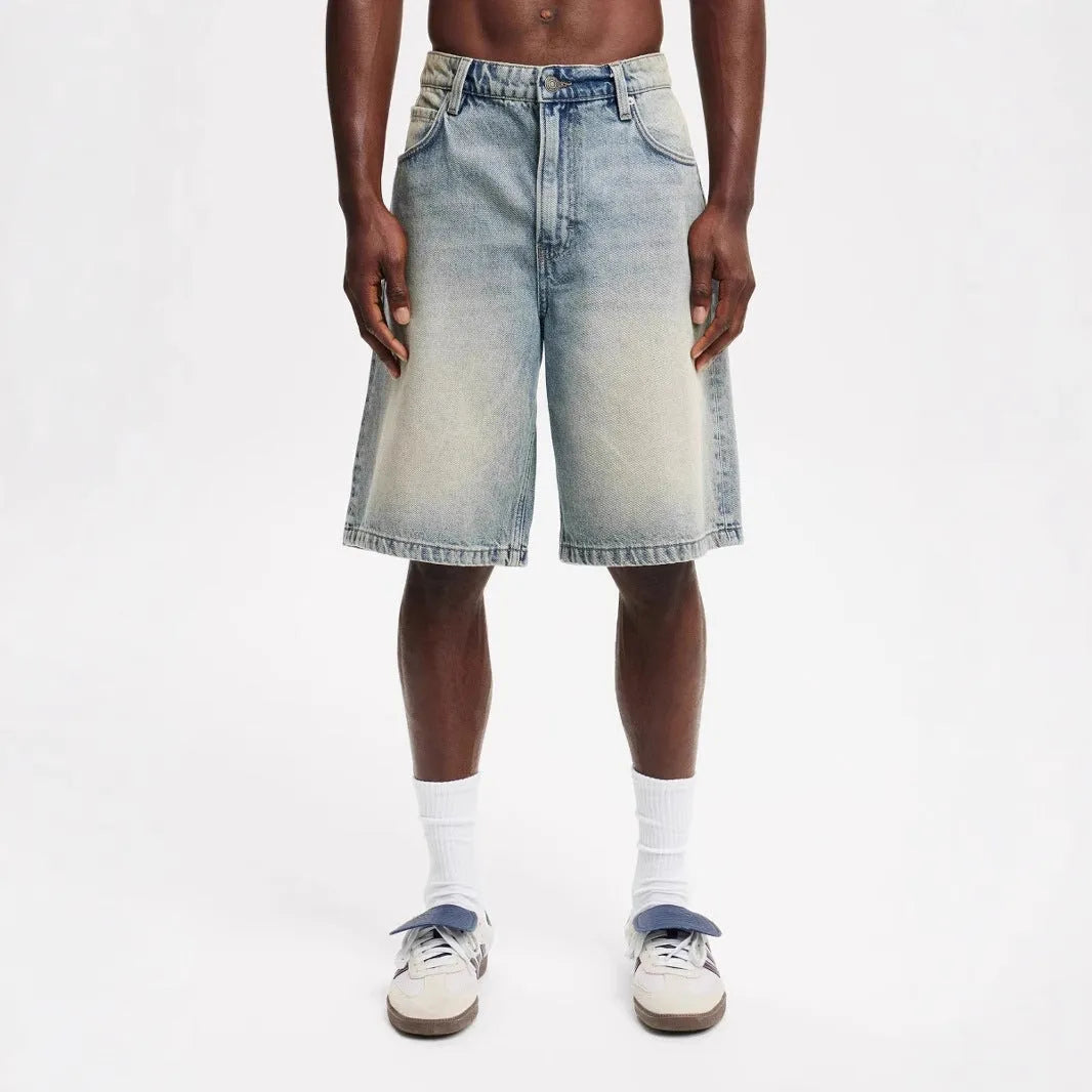 Men's light blue loose fit straight leg cotton denim jeans on a neutral background.