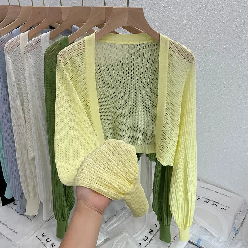 Thin loose linen blouse with hollow out lantern sleeves in apricot colour on a hanger.