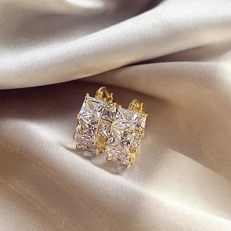 Geometric U-shaped gold ear rings with round black zircon stones