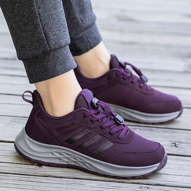 Men's and women's casual slip-on shoes with mesh upper and elastic band in black, grey, purple, and red.