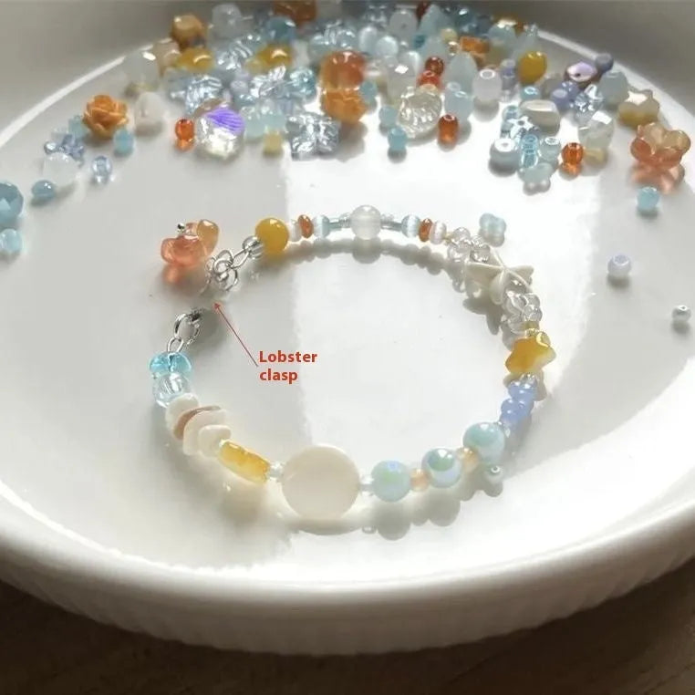 Orange summer bracelet with diamond-shaped alloy charm and round elements on mixed-material band