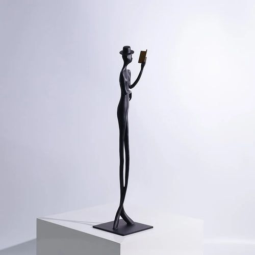 Black metal cast aluminium sculpture of reading woman on square base