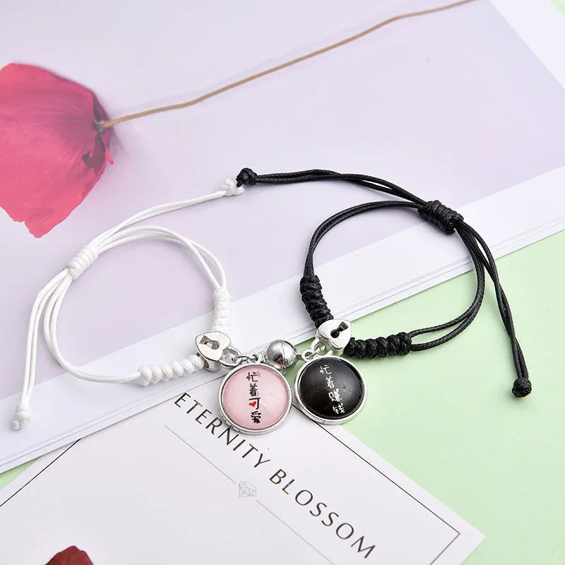 Pair of magnet couple bracelets with suction clasp on wrist, showing alloy designs like crown and love lock.