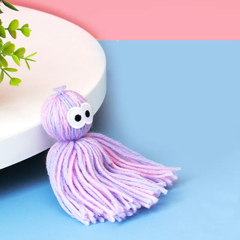 Blue grey wool cat toy with teaser stick hanging from furniture