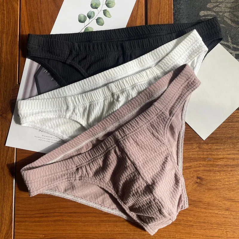 Men's solid colour cotton briefs with mid waist and triangle style in apricot black and skin colour.