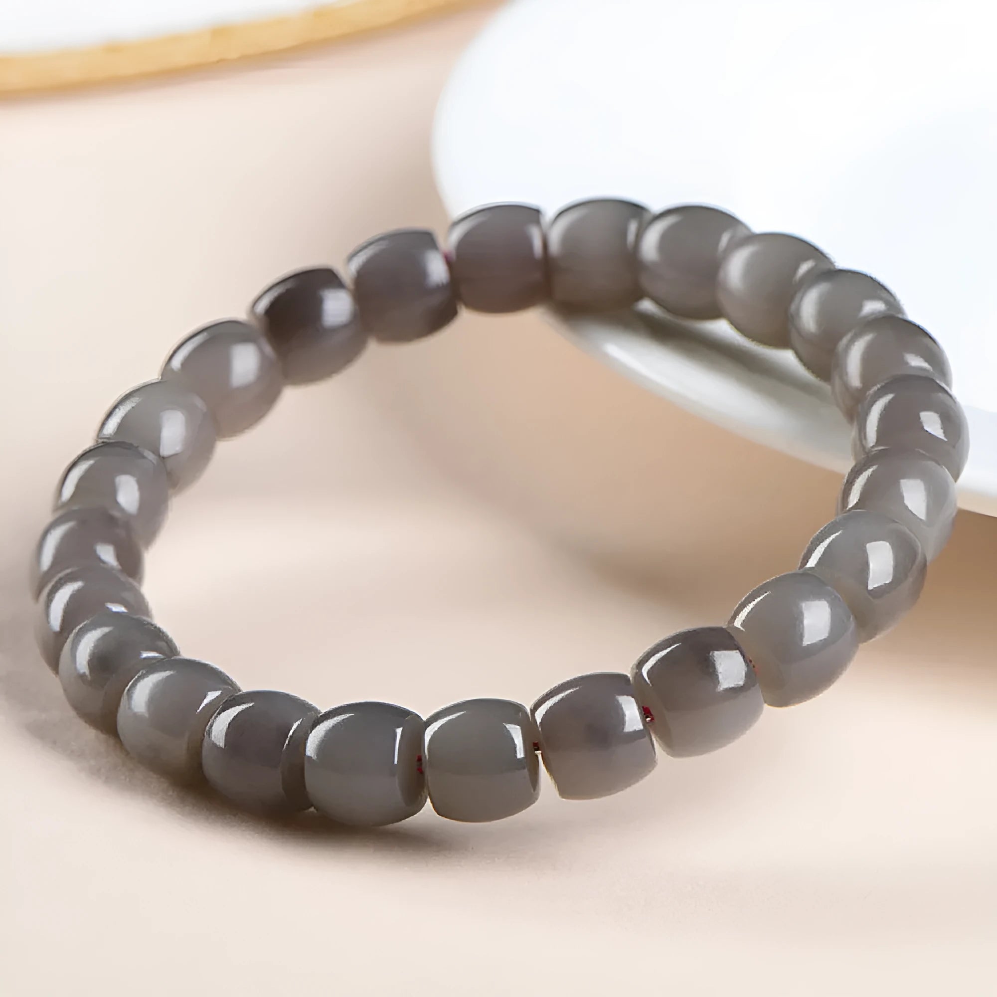 Straight cut smokey violet Hetian jade bead bracelet on a wrist, showing unisex casual style.