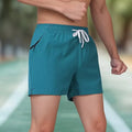 Black micro-elastic polyester men's training shorts with high waist and drawstring, laid flat.