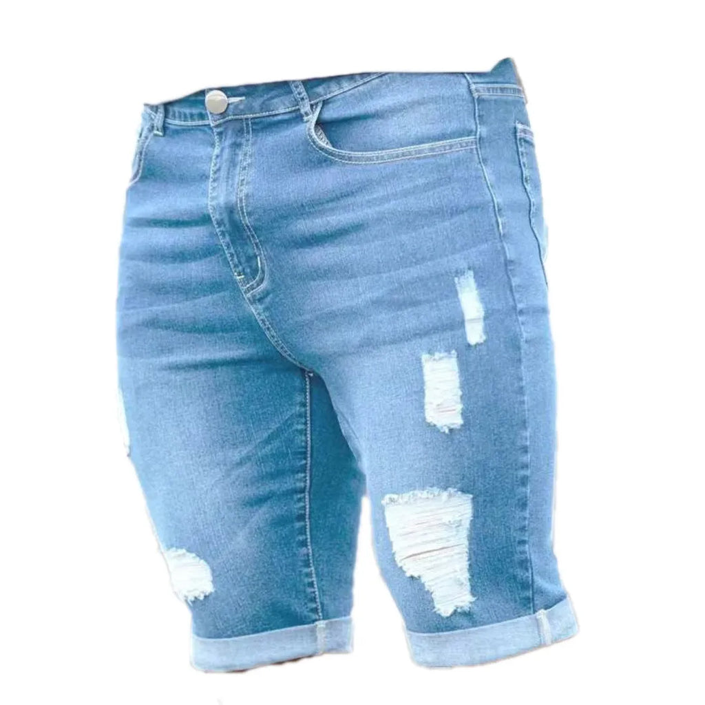 Sky blue denim shorts with multiple distressed holes and straight leg silhouette