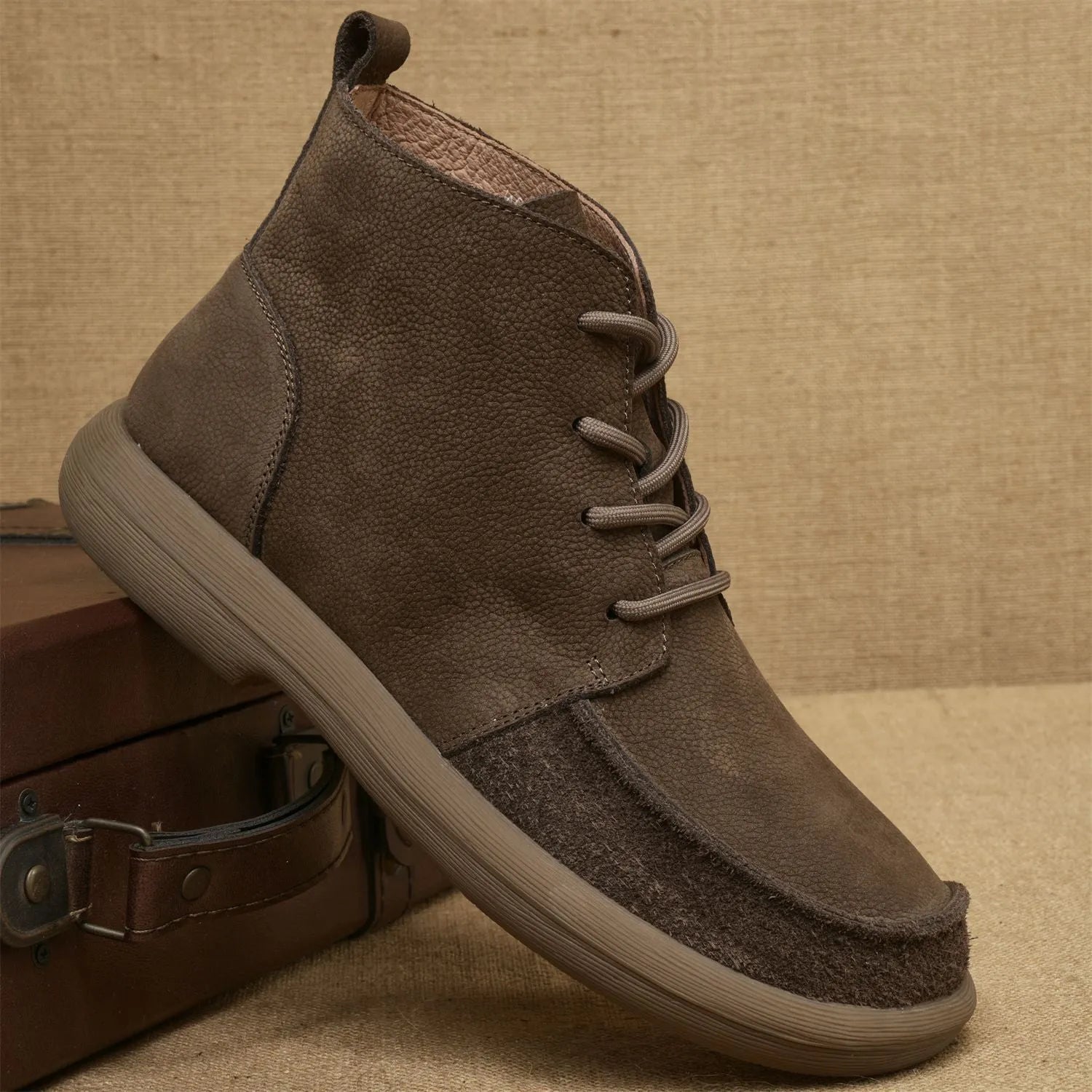 Grey genuine leather martin boots with wedge heel and front lace-up fastening on a neutral background