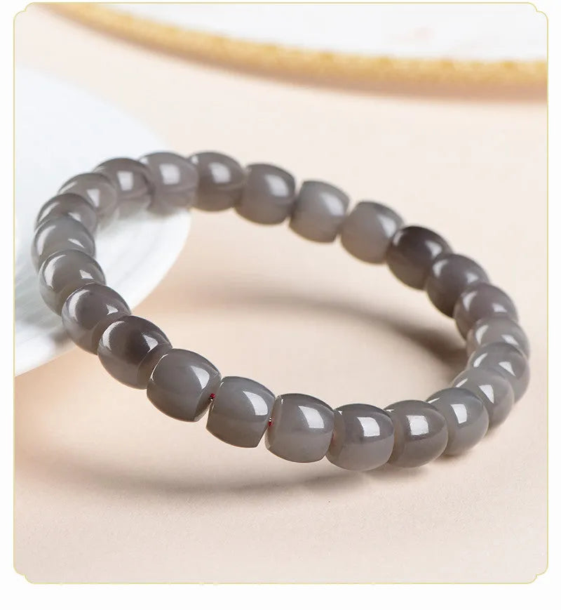 Straight cut smokey violet Hetian jade bead bracelet on a wrist, showing unisex casual style.