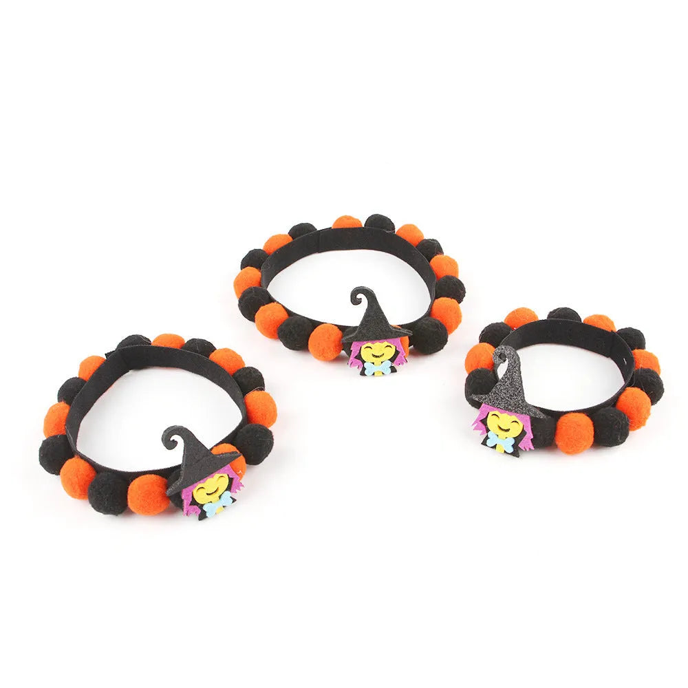 Halloween dog collar with a large orange pom-pom and pumpkin design on an adjustable black band.