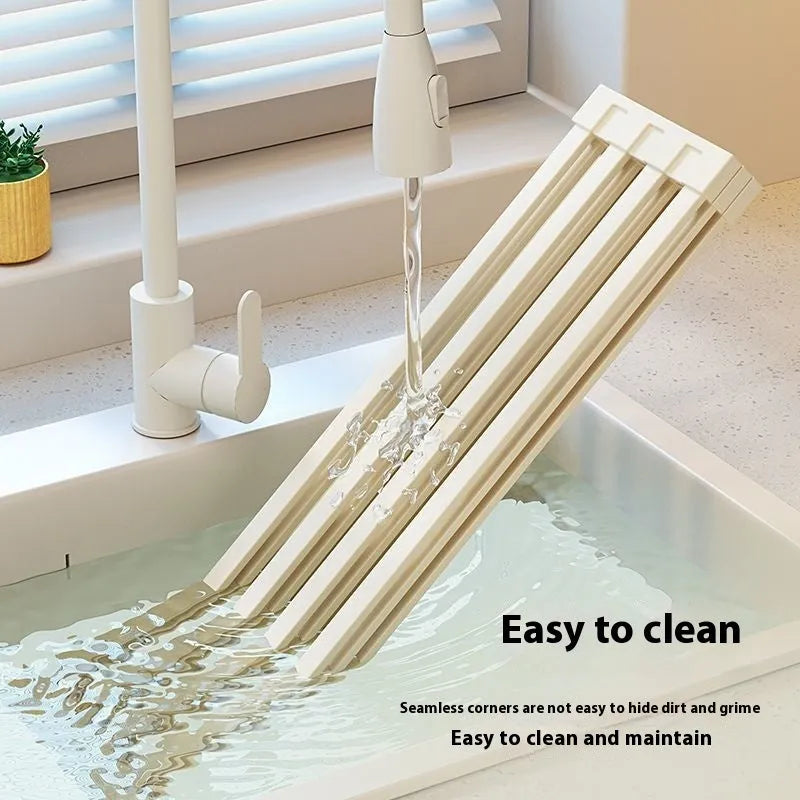 Milky white foldable stainless steel kitchen draining rack for dishes on a countertop