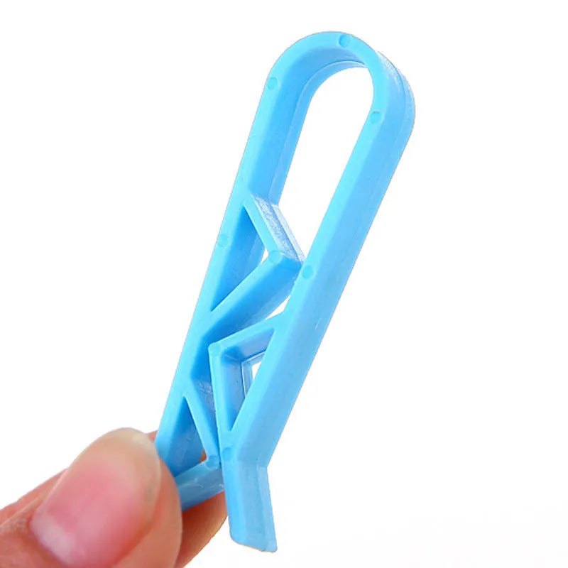 A white PP plastic clip designed to secure a bin bag to the side of a kitchen rubbish bin.