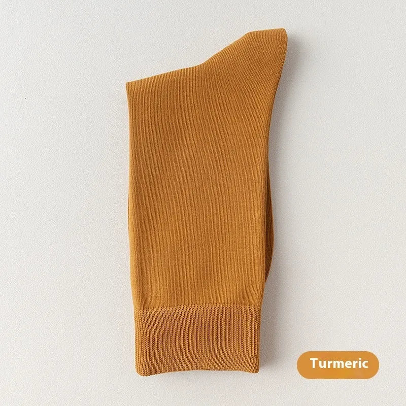 Men's solid colour pure cotton mid-calf business socks in beige, black, grey and blue shown folded.
