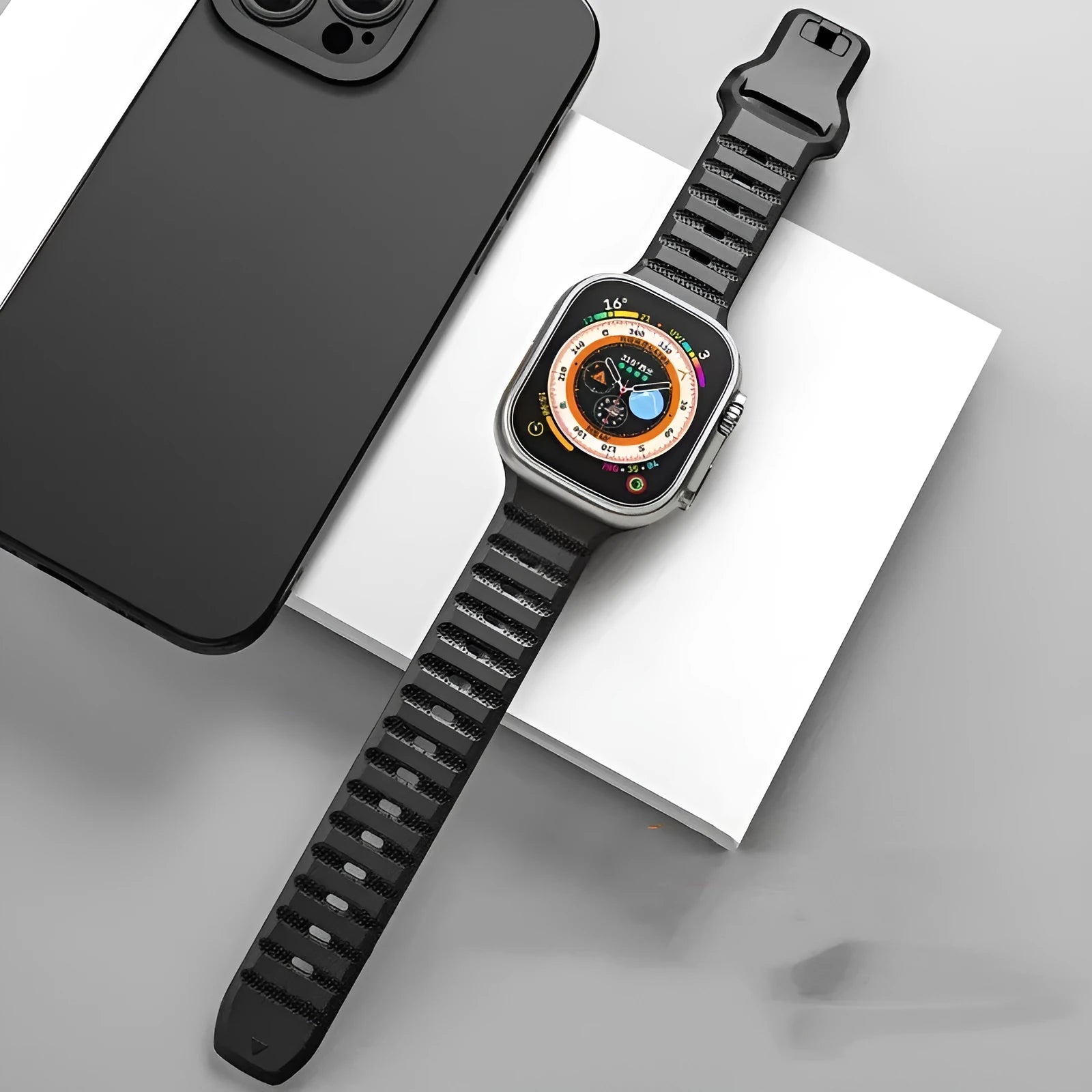 Fluoro rubber Apple Watch band with T-buckle in multiple colours on a grey background