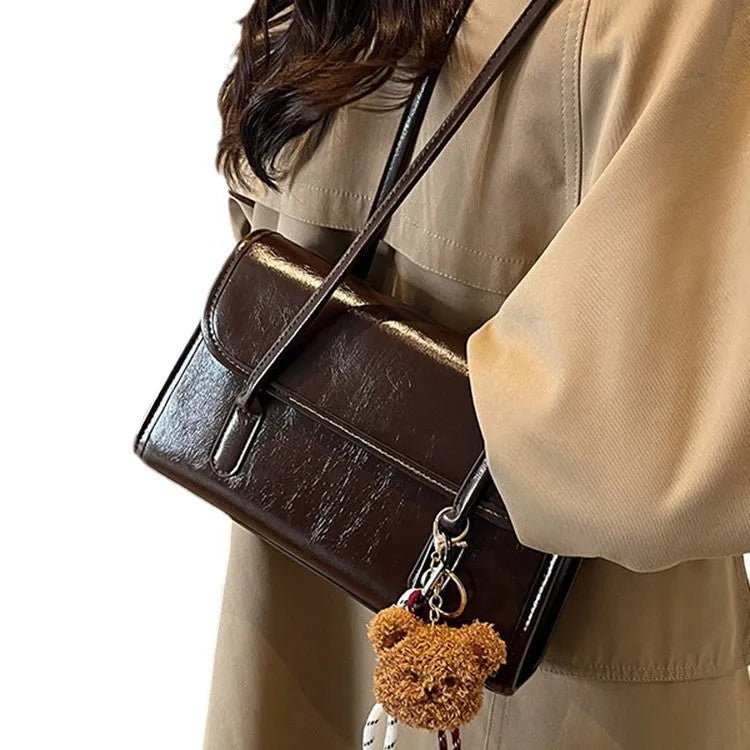 Women's brown PU leather square shoulder bag with pendant accessory showing interior zipper compartment