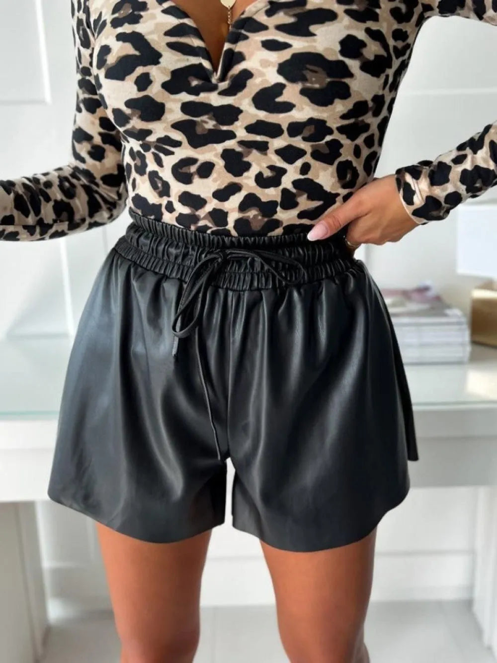 Women's black PU leather drawstring shorts with wide-leg design and lace-up waist detail