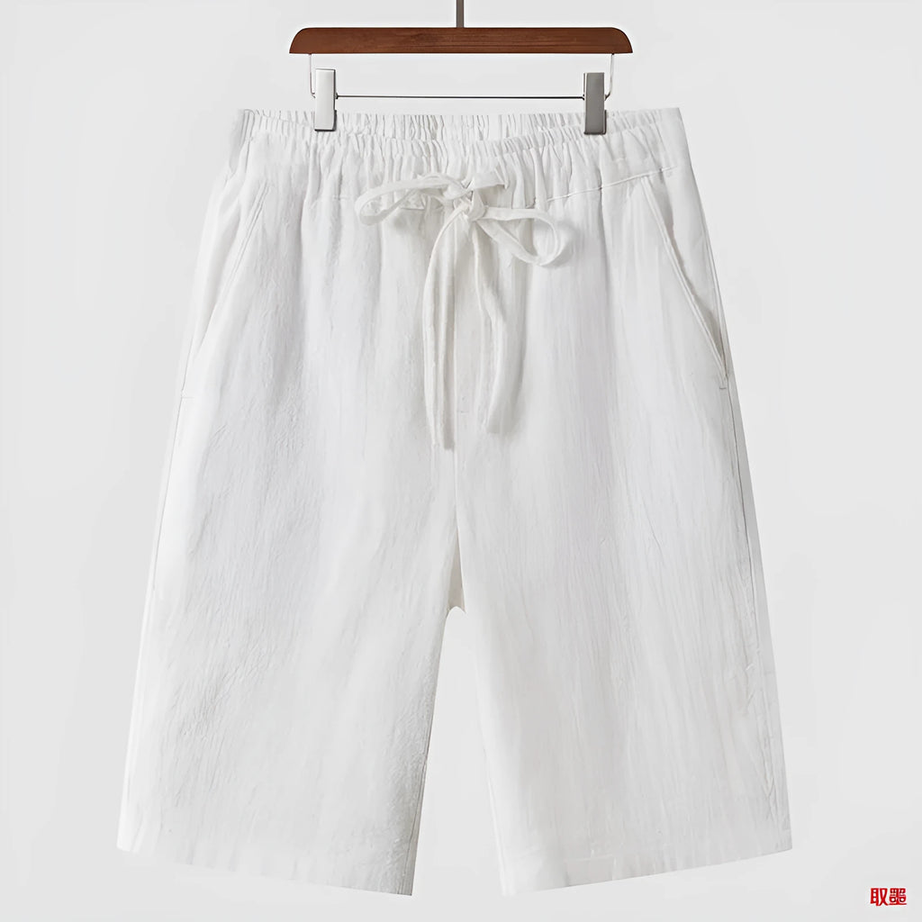 Man wearing beige linen cropped shorts with a loose fit and elasticated waist