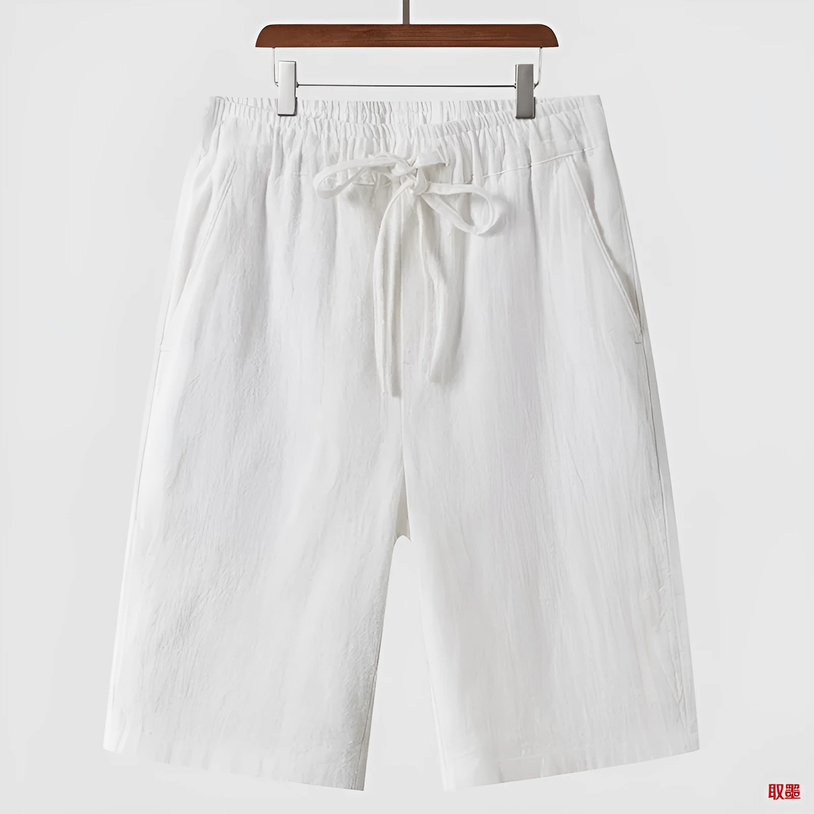 Man wearing beige linen cropped shorts with a loose fit and elasticated waist