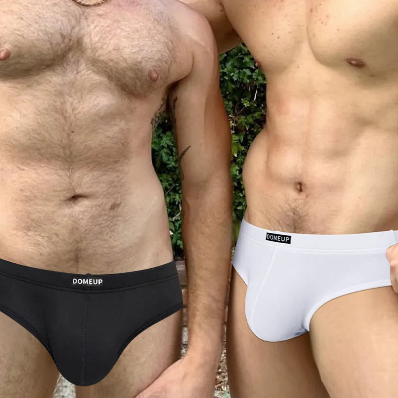 Men's solid colour seamless low-waist briefs in white, black, and pink laid flat.