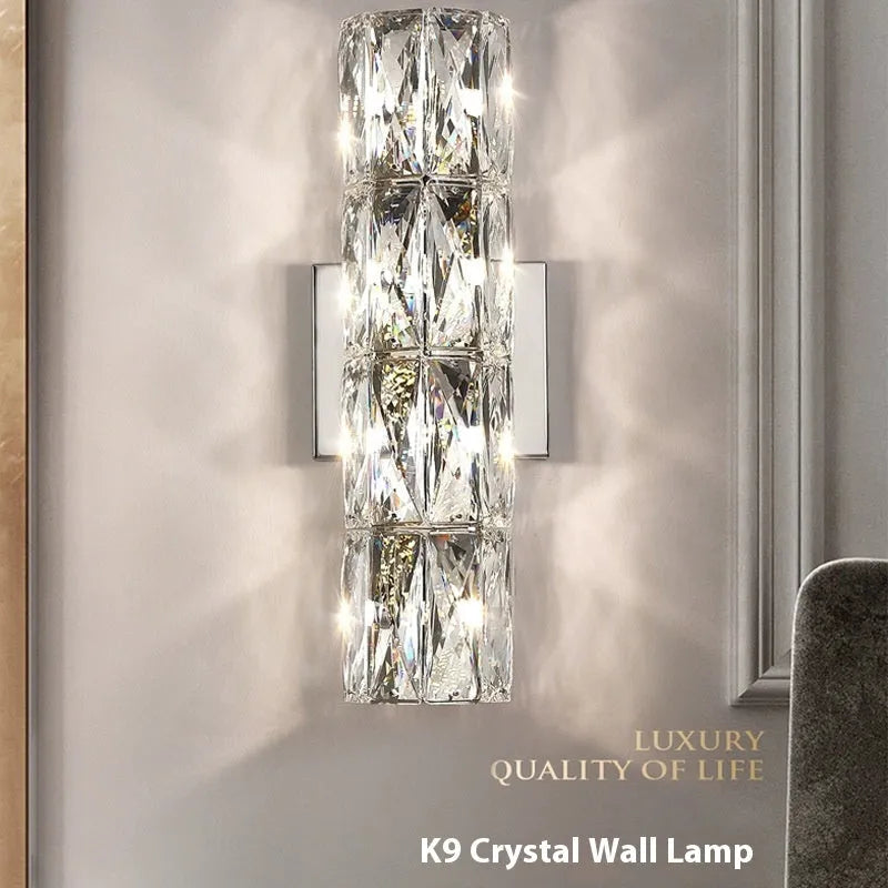 Crystal wall lamp with stainless steel frame in gold or chrome finish, mounted on a wall.