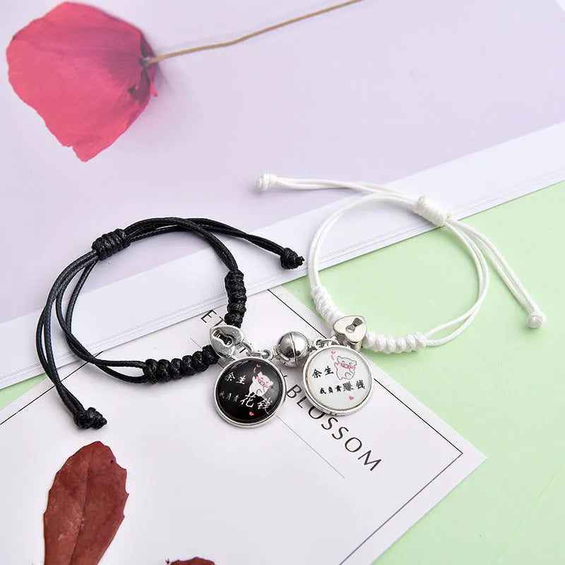 Pair of magnet couple bracelets with suction clasp on wrist, showing alloy designs like crown and love lock.