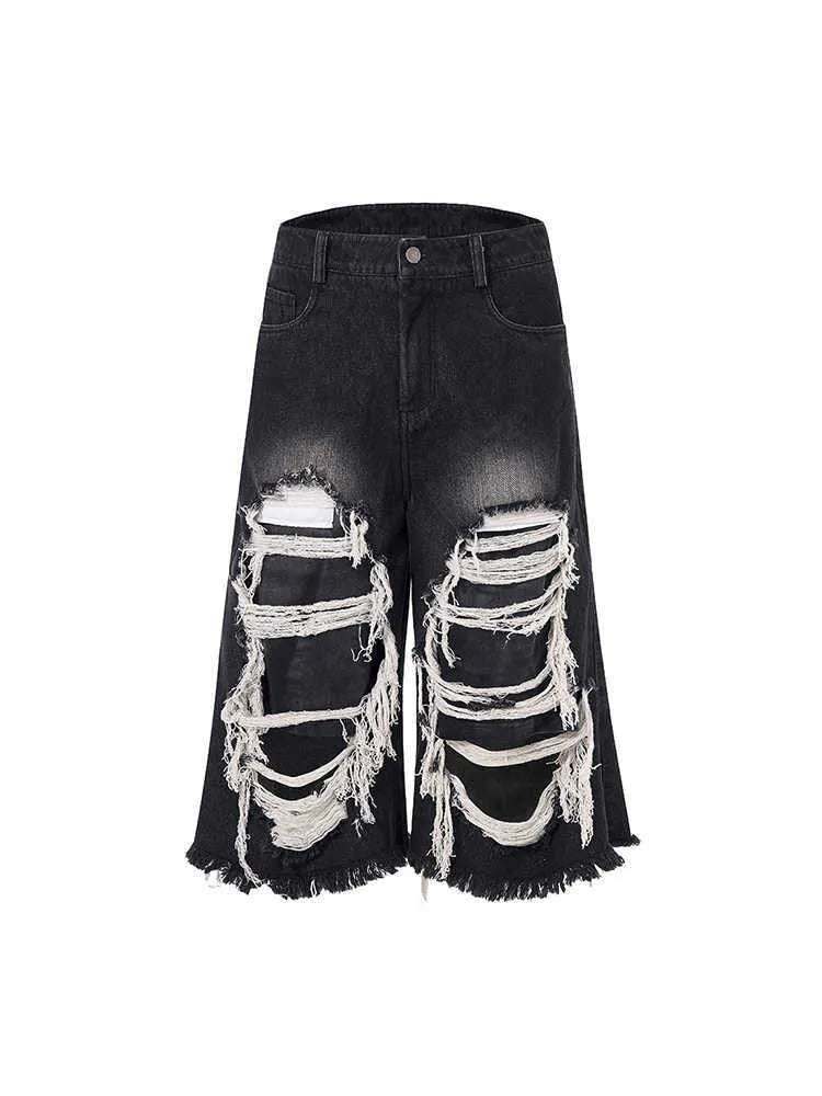 Black wide leg cropped jeans with mid-high waist and ripped patch detail on micro-elastic cotton denim