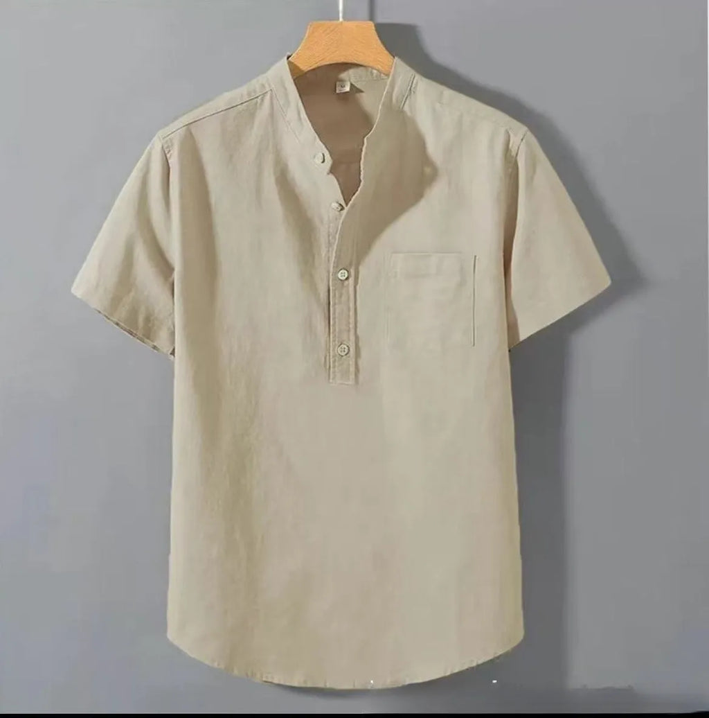 Man wearing a beige loose-fit linen shirt with a stand collar and short sleeves.