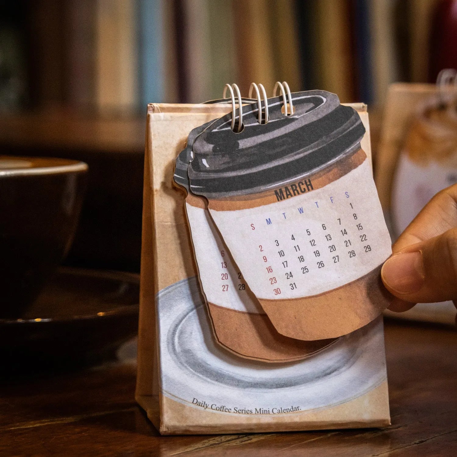 Mini coffee-themed desk calendar for 2025 showing daily pages and simple modern design