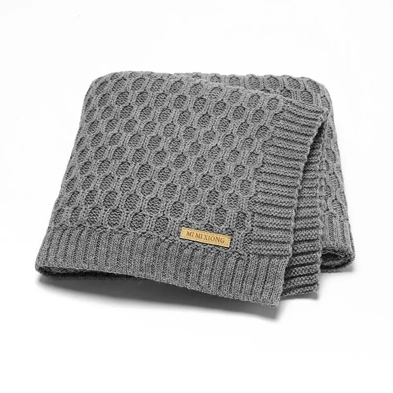 Solid colour infant hug blanket with three-dimensional line texture, shown in a choice of colours.