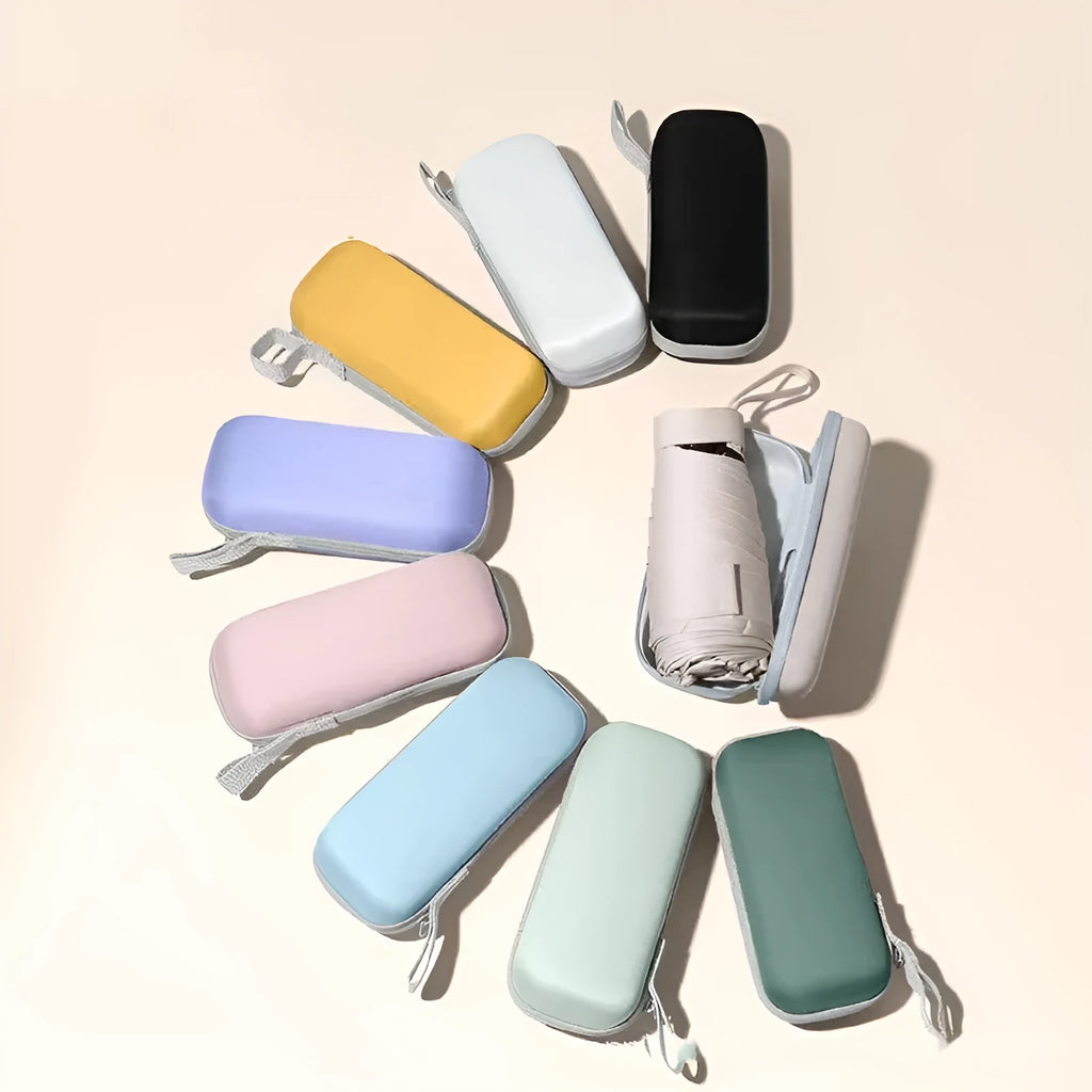 A folded six-fold flat umbrella in a capsule box, showing the steel ribs and rubber handle.