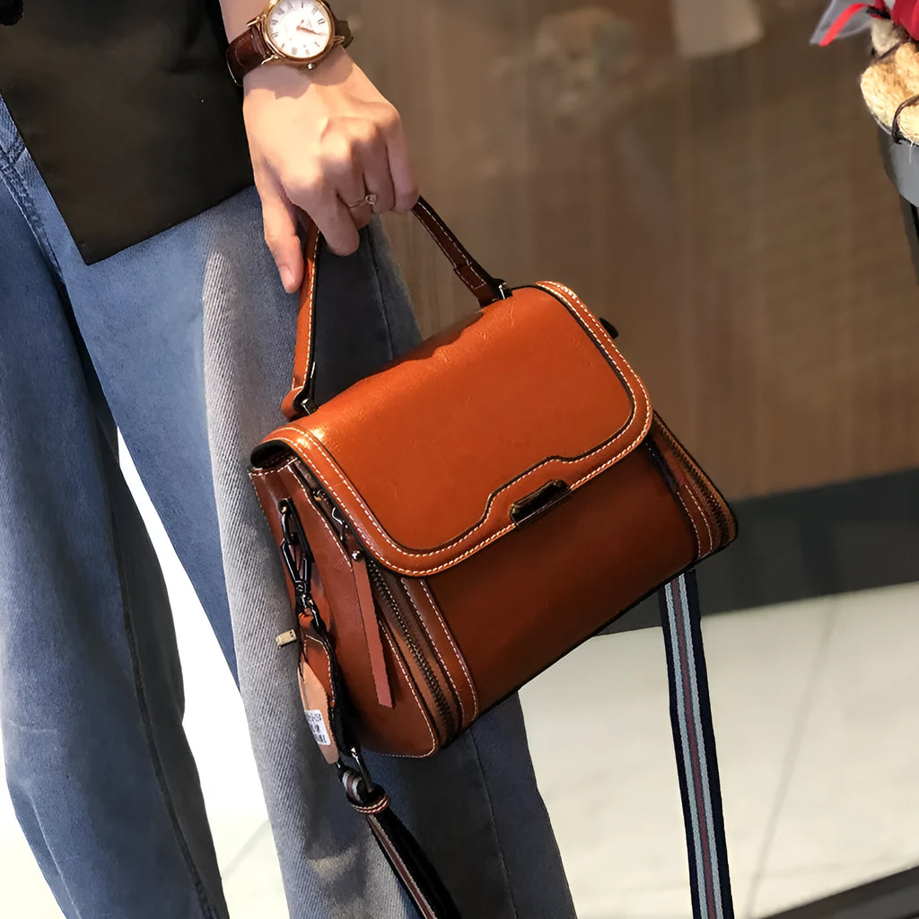 Women's brown genuine oil wax leather messenger bag with double strap and external pocket.