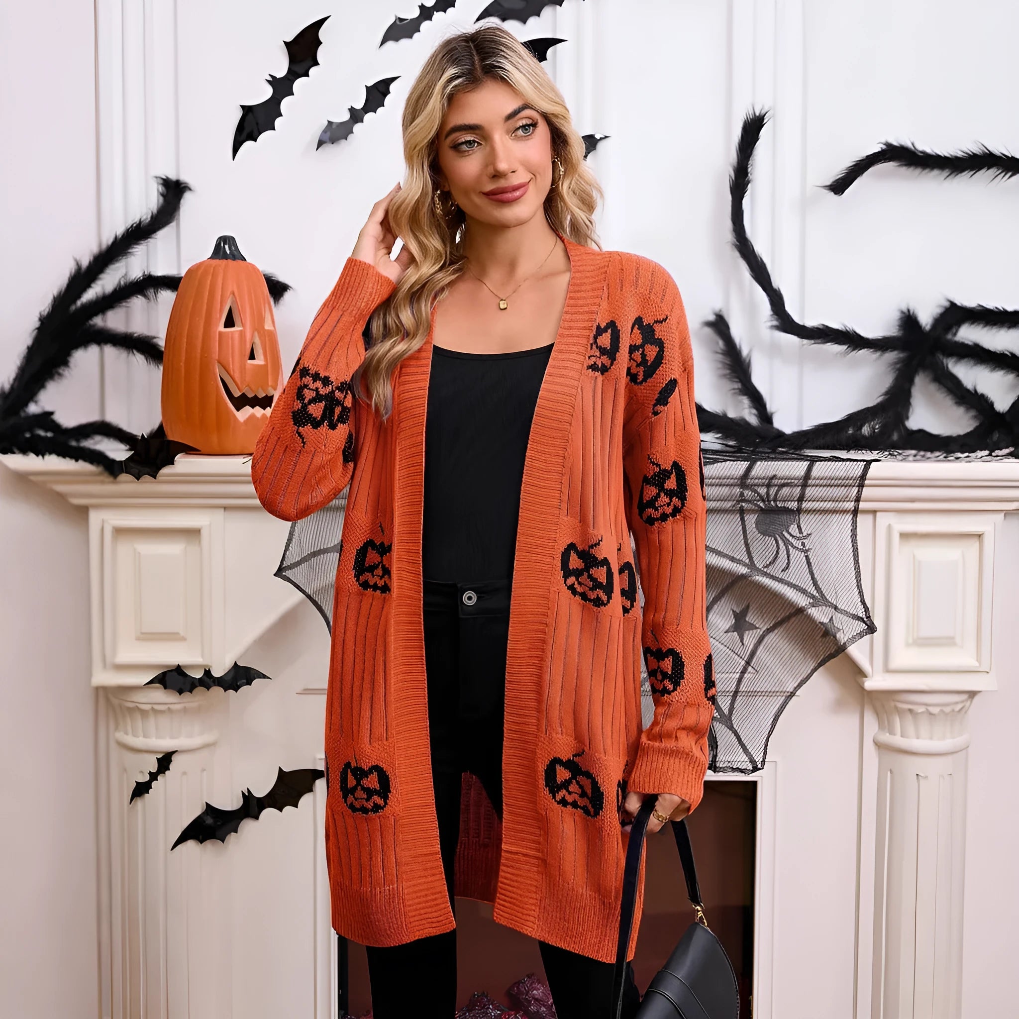 Women's black knitted cardigan with an orange pumpkin head jacquard pattern and regular sleeves.